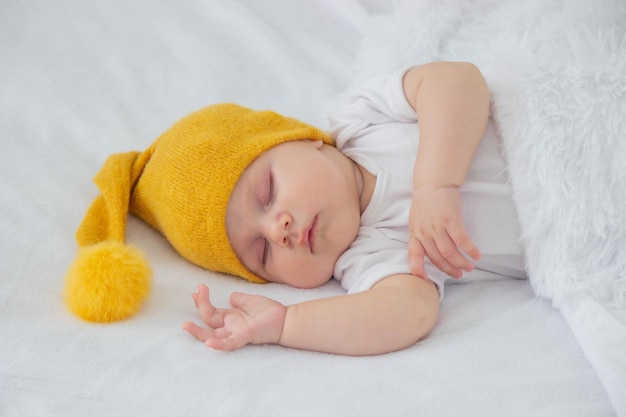 een baby in een wit bodysuit slaapt op een witte achtergrond en knuffelt een beerkind