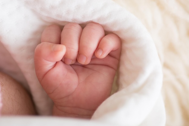 Foto een baby wordt in een witte doek gehouden met een vinger erin