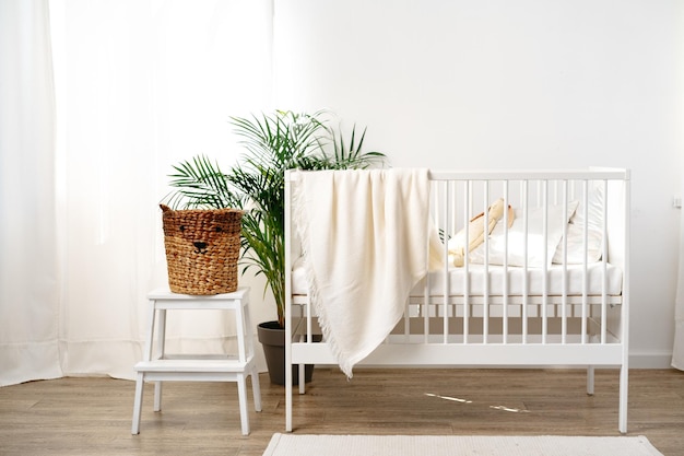 Een babydek van mousseline hangt op het bed van een kind in de verpleegkamer.