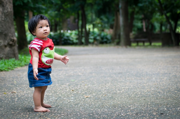 Een babymeisje begint eerst op het park te lopen