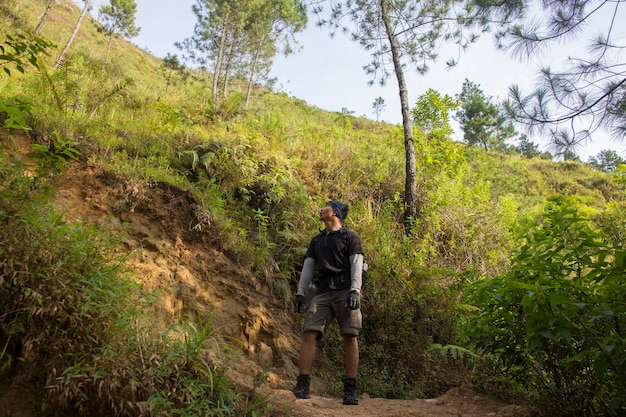 Een backpacker man reist alleen, met rugzak in de bergen