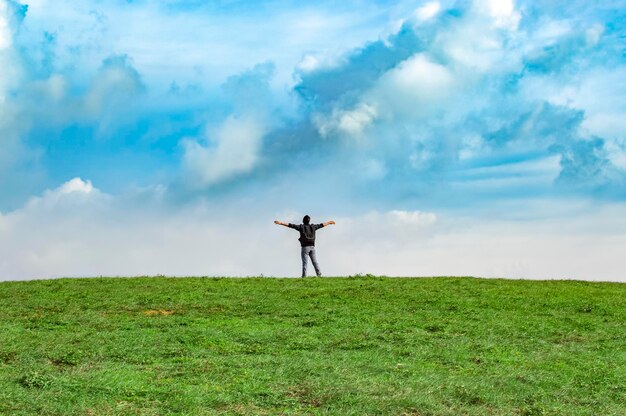 Een backpacker op een heuvel met blauwe lucht en kopieerruimte man backpacken op een groene heuvel met kopieerruimte