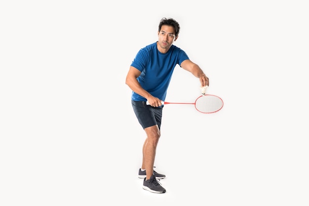 Een badmintonspeler in sportkleding staat met een racket en een shuttle