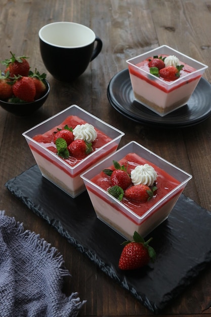 Een bakje aardbeienmousse met aardbeien erop