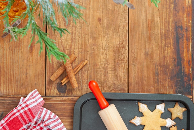 Een bakplaat met een deegroller en een rood-witte geruite handdoek aan de zijkant