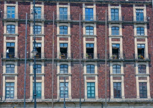 Foto een bakstenen gebouw met veel ramen en een balkon met een plantenbak op de bodem