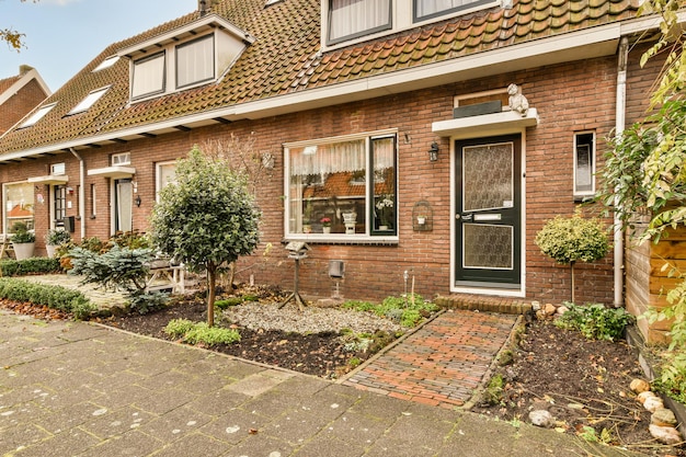 Een bakstenen huis met een tuin ervoor