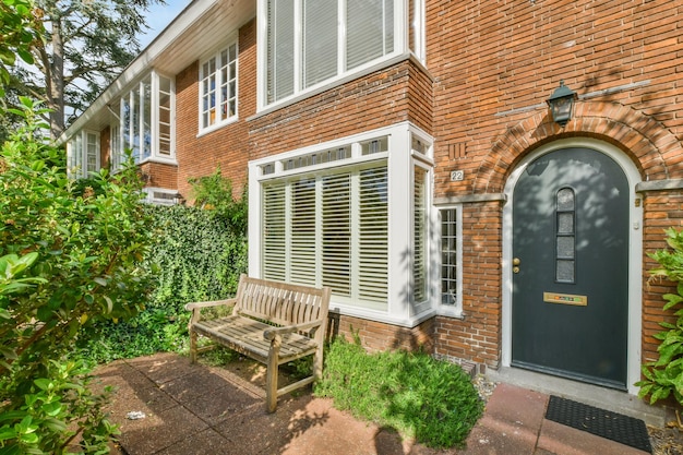 Een bank voor een bakstenen huis met een