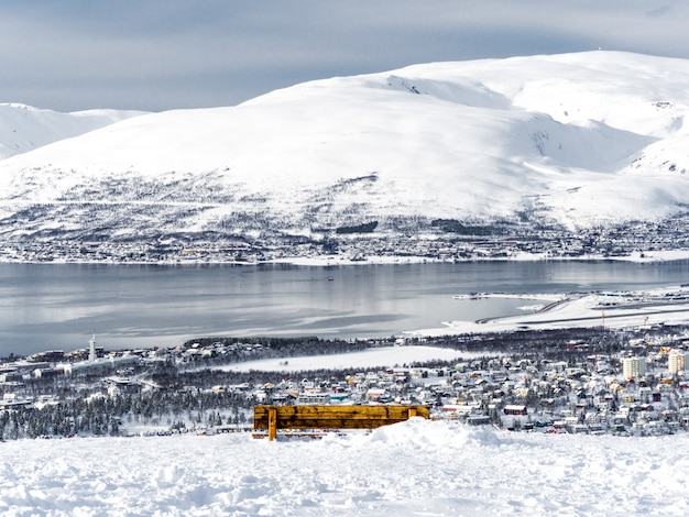 Een bankje met het oog op de stad Tromso