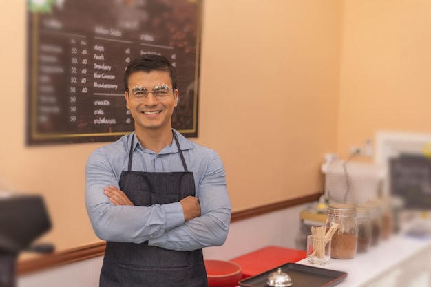 Een barista staat in zijn coffeeshop Hij lijkt trots op zijn beroep