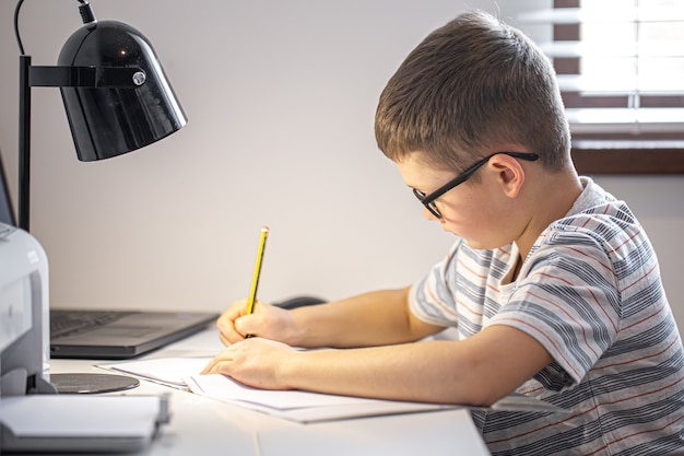 Een basisschoolleerling maakt zijn huiswerk alleen.