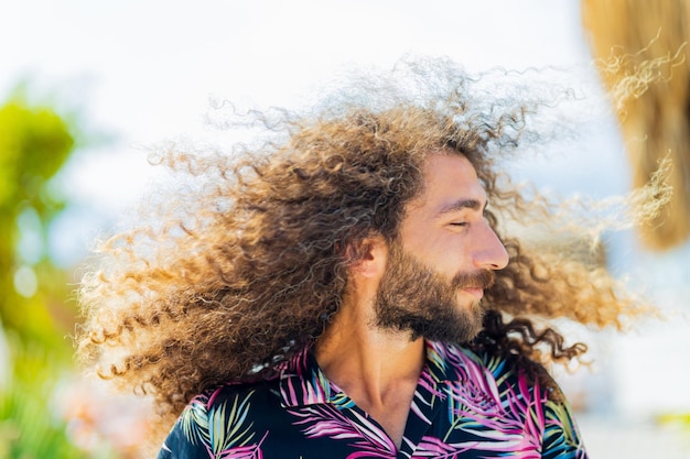 Een bebaarde en afro krullende man met krullen die buiten vliegen