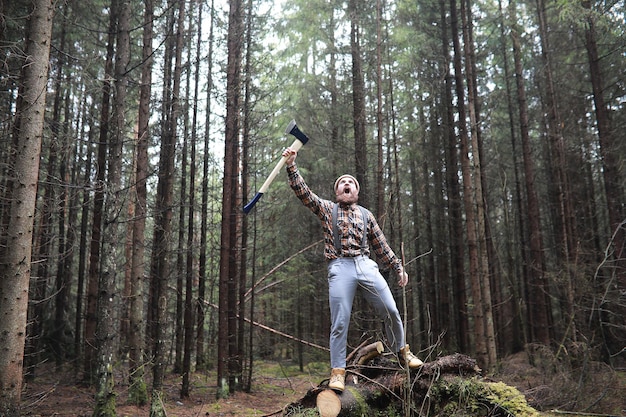 Een bebaarde houthakker met een grote bijl onderzoekt de boom voordat hij wordt geveld