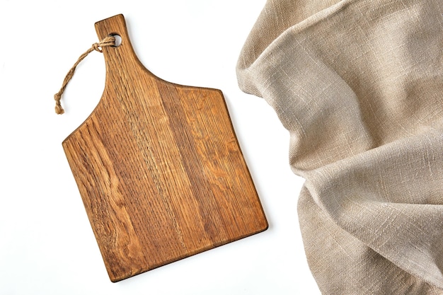 Een beige houten snijplank en een ruw beige linnen servet op een