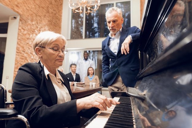 Een bejaarde vrouw speelt piano in een verpleeghuis