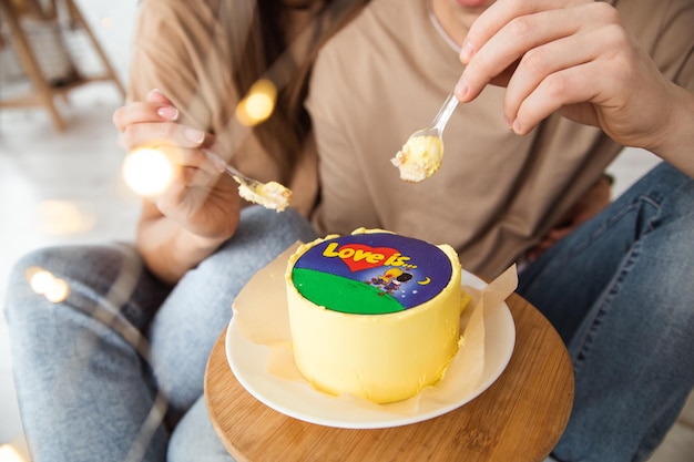 een bentocake met de inscriptie liefde is een close-up van een verliefd stel dat met lepels eet