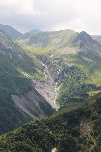 Een bergketen met in de verte een waterval.