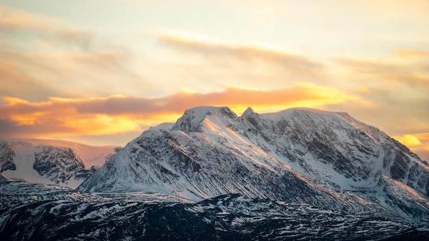 Een bergketen met sneeuw op de top en de lucht op de achtergrond