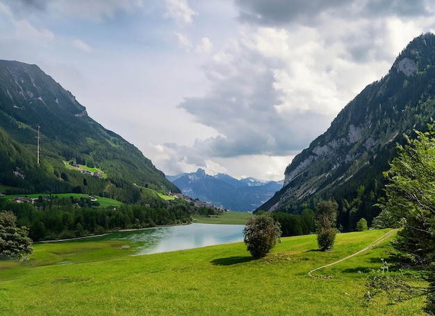 Foto een bergmeer met een groen veld en bergen op de achtergrond