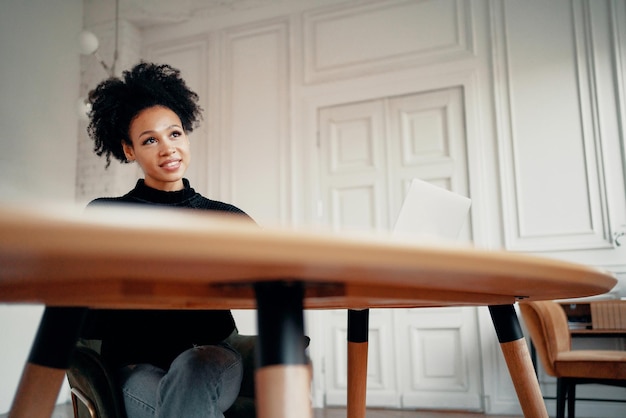 Een bericht typen aan vrienden die in een stoel zitten Portret van een vrouw met een Afro-uiterlijk