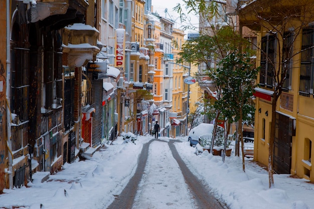 een besneeuwde straat met een rood bord dat sneeuw zegt