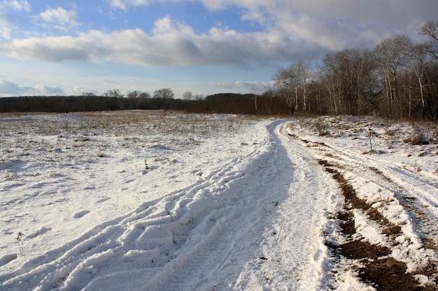 een besneeuwde weg met een band in het midden