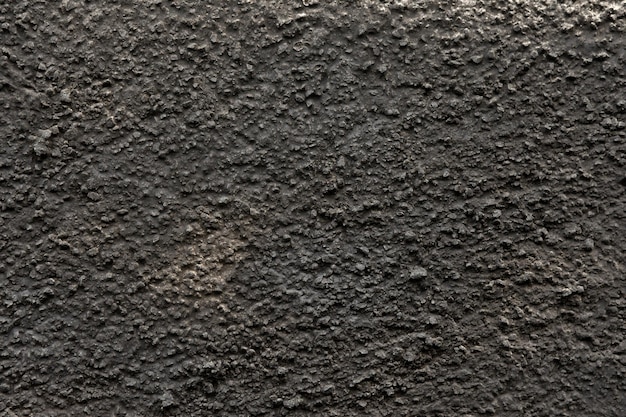 Een betonnen muur geverfd met zwarte spuitverf