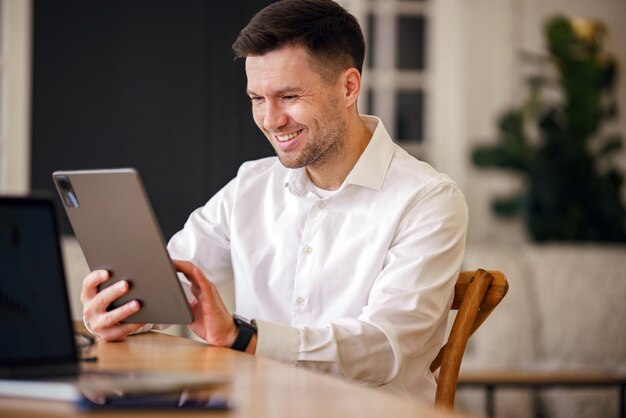 Een betrokken professional in een fris wit shirt vindt voldoening in het navigeren op een tablet