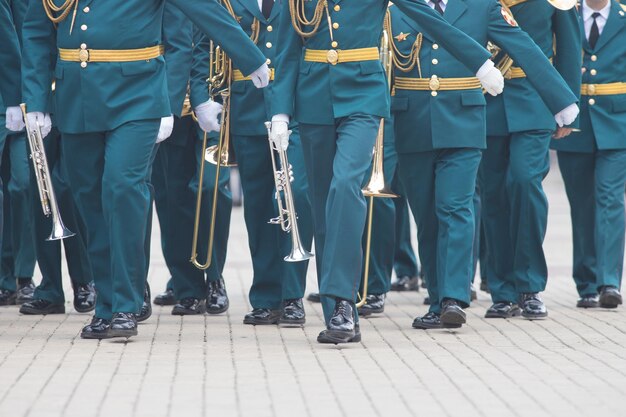 Foto een blaasinstrument parade mensen in groene kostuums lopen op straat met muziekinstrumenten