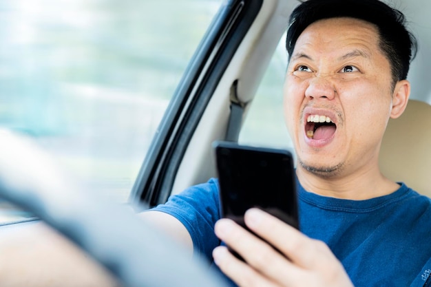 Een blanke man van middelbare leeftijd afgeleid tijdens het rijden met een mobiel