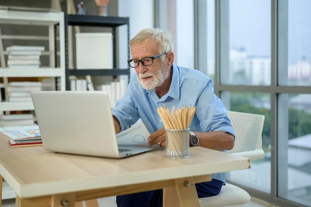 Een blanke senior zakenman die in een modern kantoor werkt