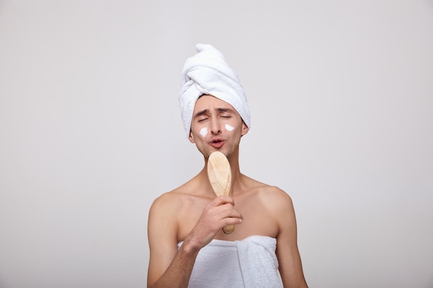 Een blanke zingt in een kam als een microfoon na een douche.