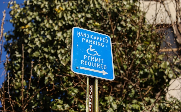 Een blauw bord met de tekst "parkeervergunning voor gehandicapten vereist".