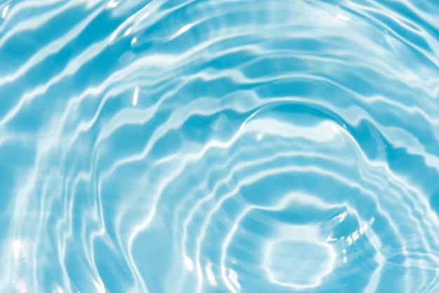 Een blauw water met een cirkel van water erin blauw water oppervlak textuur water rimpelingen glanzende bijtende stoffen