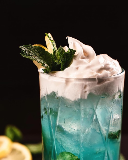 Een blauwe cocktail met limoen erop