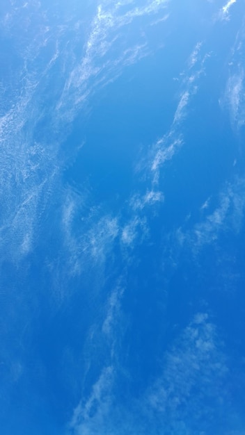 Een blauwe lucht met dunne wolken