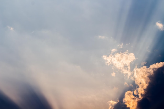 Een blauwe lucht met wolken en zonnestralen