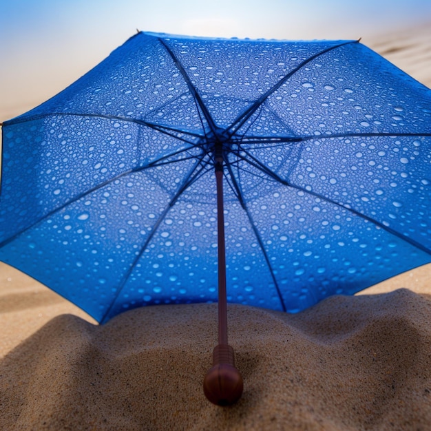 Een blauwe paraplu ligt in het zand waar de zon op schijnt.