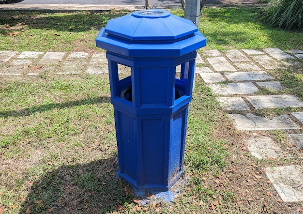 Een blauwe vuilnisbak geplaatst in een woonpark