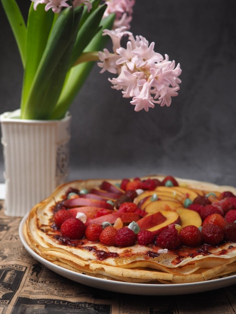 Een bloem naast een taart met fruit erop