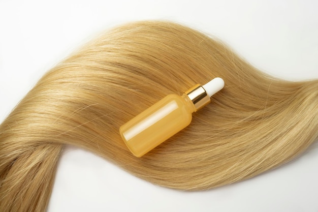 Een blonde lokken met daarop een natuurlijke olie of serum voor haarverzorging