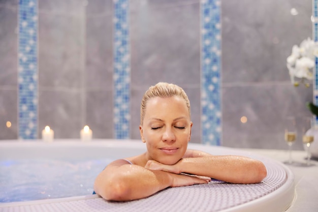 Een blonde vrouw ontspannen in de hot tub