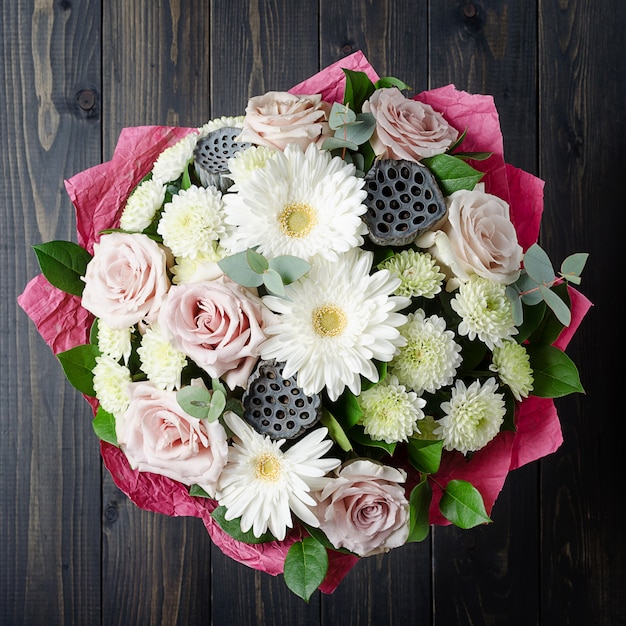 Een boeket bloemen op een donkere houten achtergrond. Boeket met rozen.