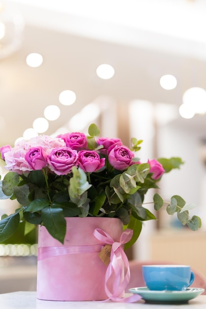 Een boeket bloemen op tafel en een kopje koffie