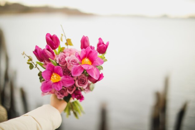 Een boeket bloemen wordt vastgehouden door een persoon die het vasthoudt.