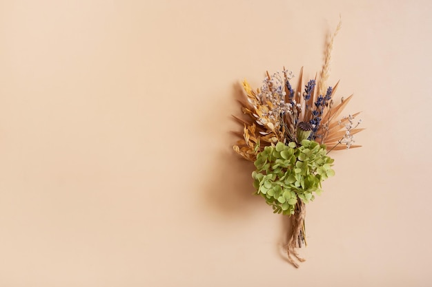 Een boeket droge bloemen en kruiden op beige achtergrond Kopieer ruimte voor tekst