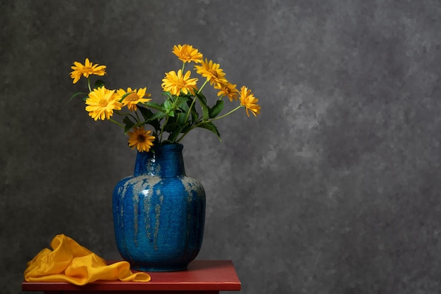 Een boeket gele herfstkleuren in een grote blauwe vaas op een donkergrijze achtergrond Rustig stilleven Relax Felle kleuren Pleasure Home interior