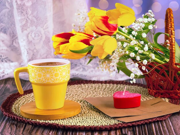 Een boeket rode en gele tulpen in een mand gypsophila bloemen een gele kop koffie