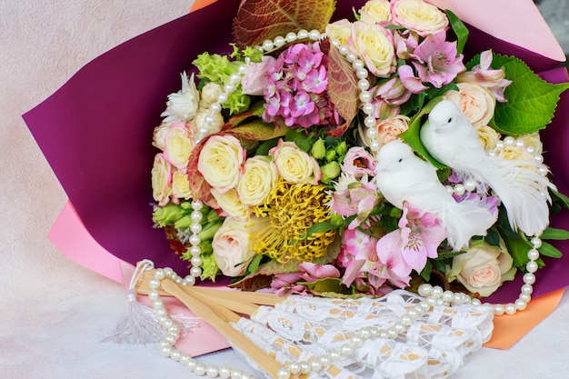 Een boeket rozen, hortensia's en twee witte duiven, parelkralen