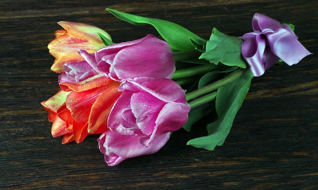 een boeket van kleurrijke bloemen op een houten tafel.